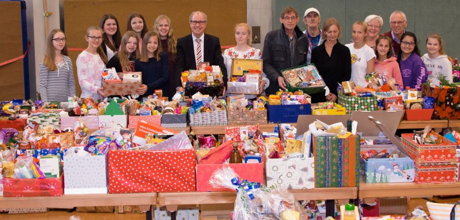 Haben Weihnachtspäckchen an Bedürftige verteilt: Landrat und Schirmherr der Paderborner Tafel Manfred Müller (8. von links), Vorsitzende der Paderborner Tafel Uwe Hoffmann (10. von links), Günther und Rita Bach (4. und 5. von rechts), Anita Meierfrankenfeld (7. rechts), Klaus Grandt (8. von rechts) (alle Ehrenamtliche der Paderborner Tafel und die Schülerinnen und Schüler des Gymnasiums St. Michael mit Schülersprecherin Nora Schulze (9. von links) (Foto: Amt für Presse- und Öffentlichkeitsarbeit, Kreis Paderborn, Anna-Sophie Schindler)